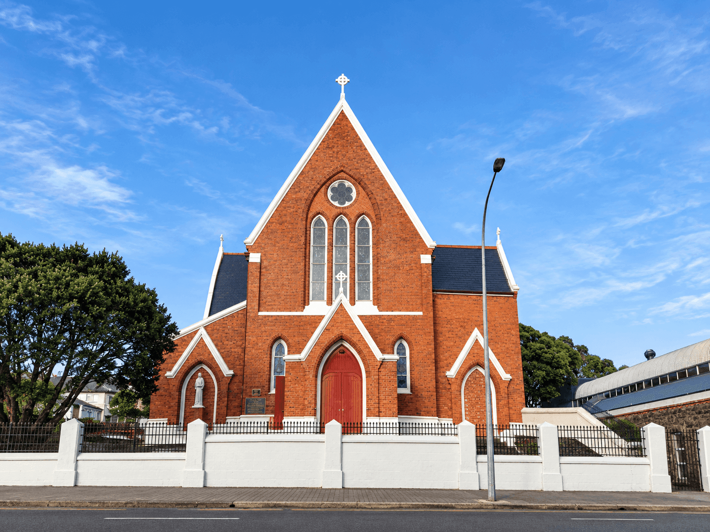 Red-brick Gothic facade of St Benedict's Church under a blue sky