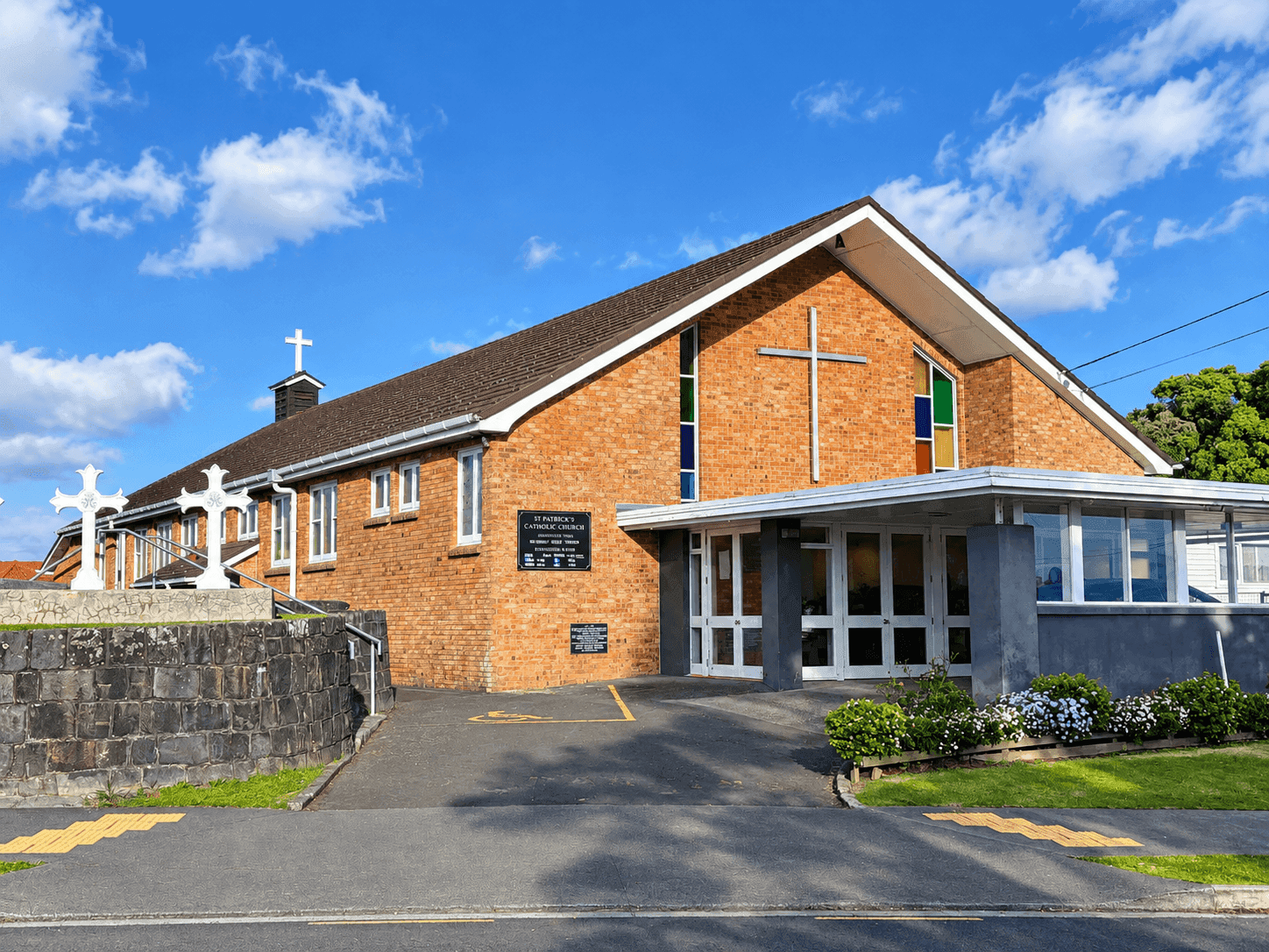Brick St Patrick's Church, Panmure, with white crosses on the roof and front wall